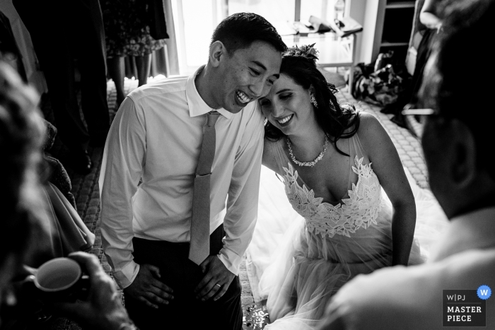 Photo by: <a href="https://www.wpja.com/contests/2019-v10/best-wedding-photographers/2543897">Sarah V. Martinez - Dover New Hampshire</a> Wedding Photographer for the Dockside Guest Quarters in York Maine | The bride and groom laugh during the traditional tea ceremony on their wedding day