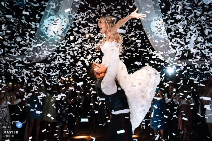 Zdjęcie: <a href="https://www.wpja.com/contests/2019-v11/best-wedding-photographers/2544310"> Andy Griffiths - St. Helens Lancashire </a> Zdjęcie z przyjęcia weselnego w Rivington Barn przedstawiające pana młodego podnoszącego pannę młodą, gdy są oblewani konfetti.