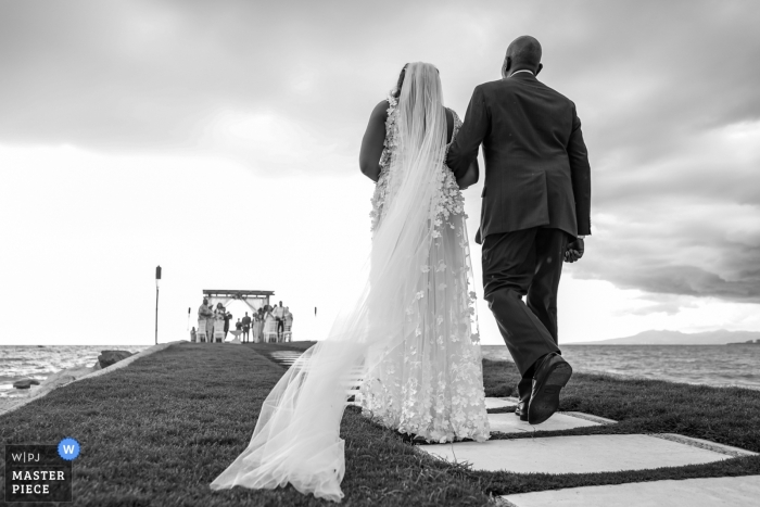 Fotografia in bianco e nero di una sposa con suo padre che cammina lungo il corridoio per un matrimonio di Villa Premiere. Fotografi di Vallarta, in Messico.