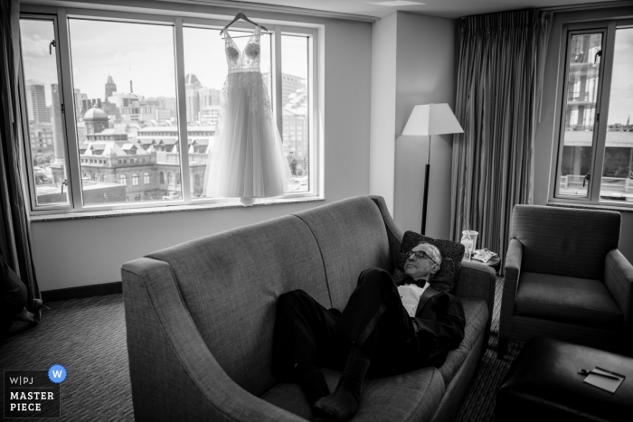 Baltimore, MD Photographie de mariage d'un père faisant la sieste pendant que les filles se préparent pour le mariage.