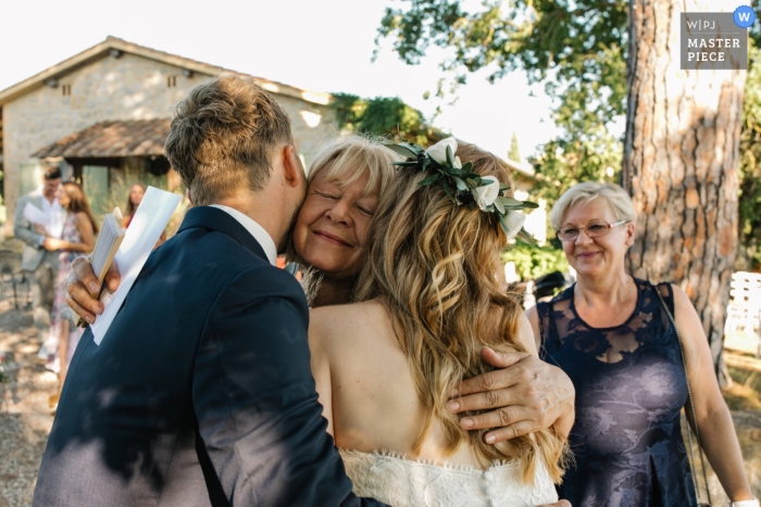 Mamma van de bruid die bruid en bruidegom koestert bij hun huwelijk van Tenuta Corsignano Toscanië.