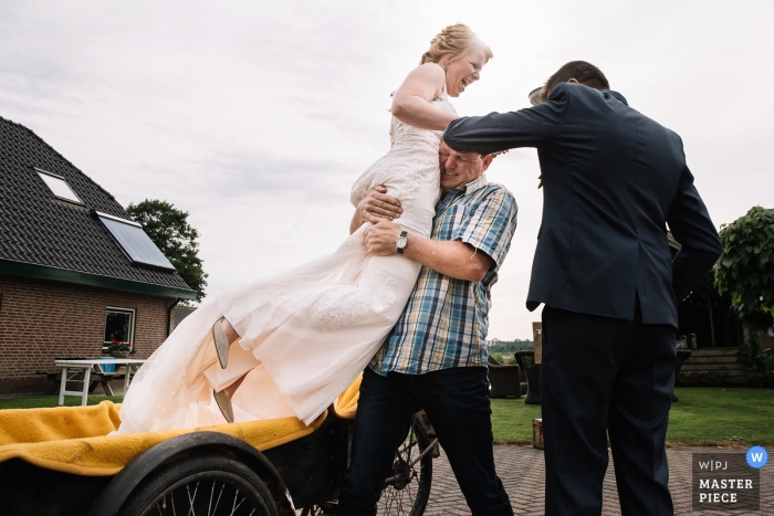 Photo by: <a href="https://www.wpja.com/contests/2019-v11/best-wedding-photographers/2545399">Corine Nap - Veenendaal Utrecht</a> Netherlands Home bride getting ready images - Father of the bride gets bride out of bike on wedding day.