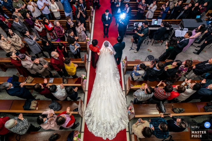 Zdjęcie: <a href="https://www.wpja.com/contests/2019-v11/best-wedding-photographers/2545670"> Will Tee - Taipei City </a> Zdjęcia ślubne kardynała Tien Cultural Center - w tej chwili, gdy rodzice panny młodej wyprowadzili pannę młodą na spotkanie pana młodego w korytarzu z czerwonego dywanu, lampa błysnęła w aparacie fotografa.