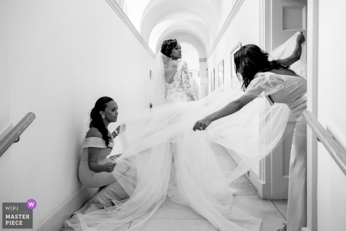 Photo by: <a href="https://www.wpja.com/contests/2019-v11/best-wedding-photographers/2545858">Panayis Chrysovergis - London London</a> Wedding Photography at Fulham Palace of a bride having the final touches done on her dress by her bridesmaids.