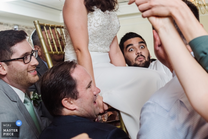 Zdjęcie: <a href="https://www.wpja.com/contests/2019-v11/best-wedding-photographers/2546279"> Meg Brock - Holland Pensylwania </a> Horsham, PA zdjęcia ślubne - Znalezienie jego siły podczas tańca krzesła panny młodej na przyjęciu