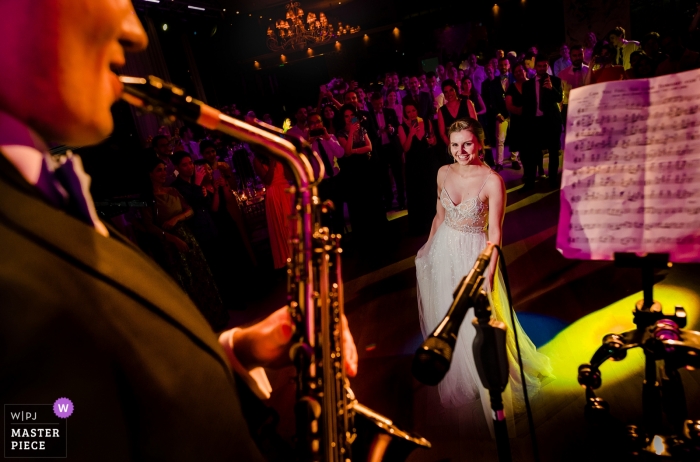 Photo by: <a href="https://www.wpja.com/contests/2019-v11/best-wedding-photographers/2546340">Vlad Lodoaba - București</a> Bamboo Club, Bucharest Wedding venue photography | Bride watches as groom plays Lion King theme on the saxophone