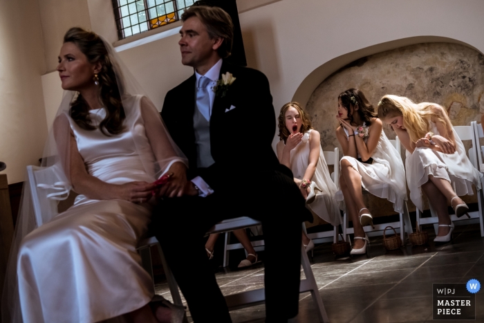 Photo by: <a href="https://www.wpja.com/contests/2019-v11/best-wedding-photographers/2546466">Isabelle Hattink - Rotterdam Zuid Holland</a> Bridesmaids are bored during ceremony in Naarden - Wedding Reportage Photographer
