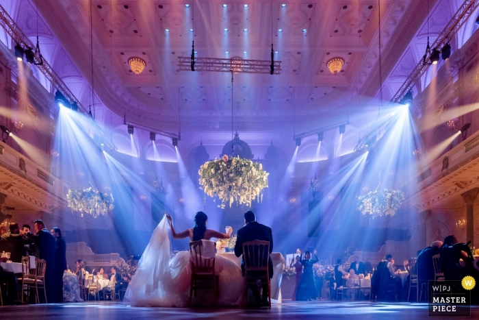 Photo by: <a href="https://www.wpja.com/contests/2019-v11/best-wedding-photographers/2546518">Gerhard Nel - The Hague Zuid Holland</a> Musical hall in Amsterdam - Wedding Photos - The wedding couple dining in the centre of the venue as the rest of the guests are situated around round tables surrounding them.