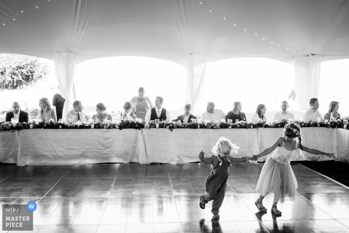 Roozengaarde Wedding Reception Photographer | Two kids run around the dance floor during wedding reception 