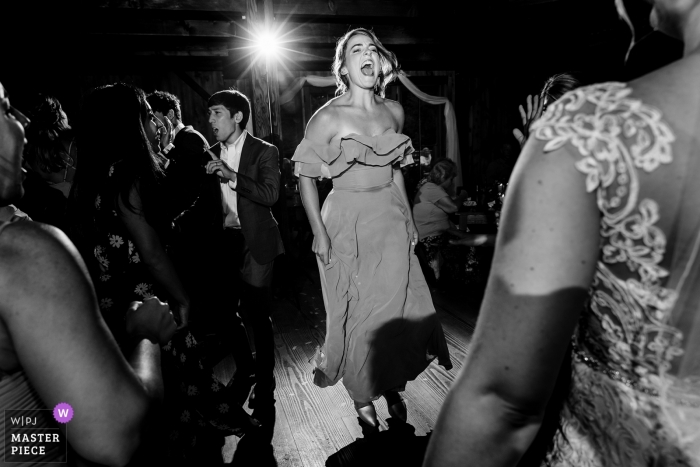Photo by: <a href="https://www.wpja.com/contests/2019-v11/best-wedding-photographers/2546613">Sarah V. Martinez - Dover New Hampshire</a> The Preserve at Chocorua in Tamworth, NH Wedding Photography | The maid of honor gets wild on the dance floor at her best friend's wedding as the bride watches