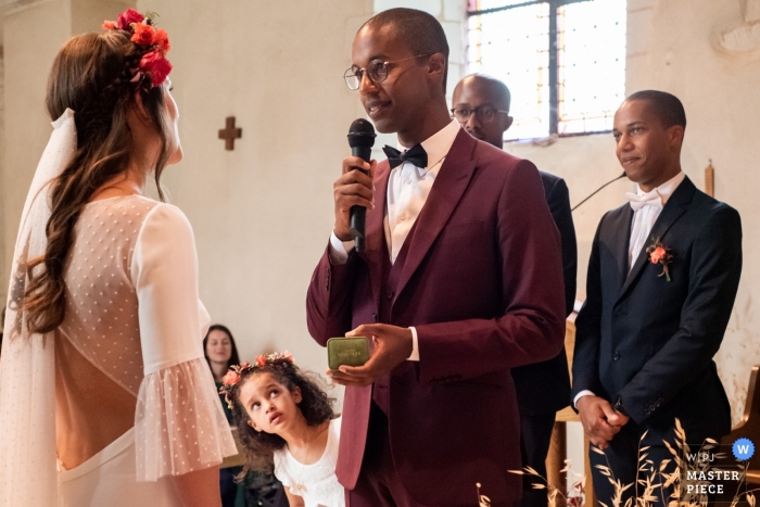 Photo by: <a href="https://www.wpja.com/contests/2019-v12/best-wedding-photographers/2547716">Estelle Offroy - La Varenne </a> Church, Beaucouzé 49 France Wedding Photographer | The groom pronounces his vows and his niece is watching him.