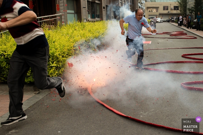 The groom took the bride home and set off firecrackers China wedding day photography | The groom took the bride home and set off firecrackers at the door of the house.