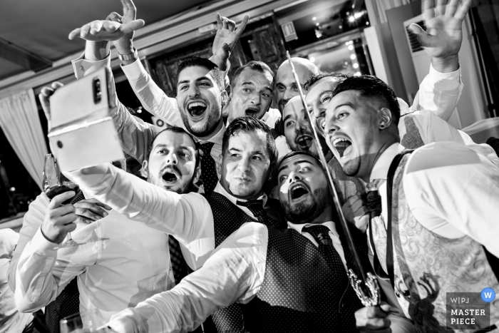 Mirador de Cuatro Vientos trouwfoto van de bruidegom en groomsmen die een selfie maken (met een zwaard)