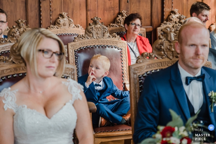 Foto von: <a href="https://www.wpja.com/contests/2019-v12/best-wedding-photographers/2548386"> Nadine Lotze - Hagen Nordrhein-Westfalen </a> Rathaus Bückeburg dokumentarische Hochzeitsfotografie während der Zeremonie | kleiner Junge gestikuliert leise zu sein