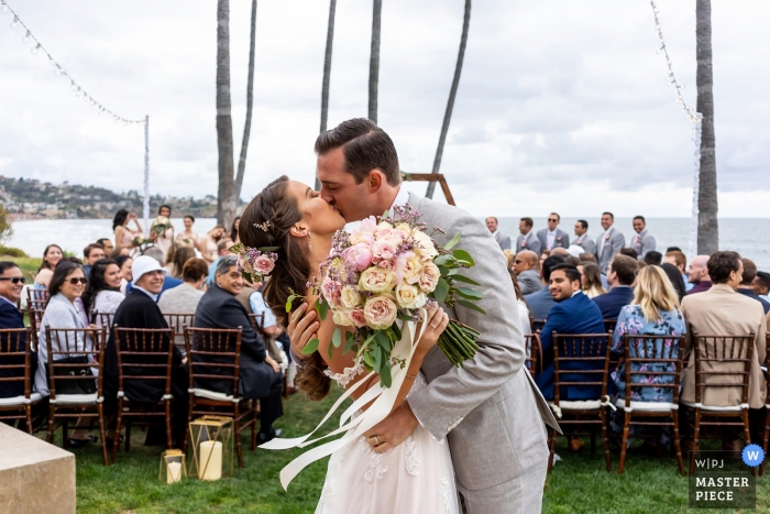 Photo: <a href="https://www.wpja.com/contests/2019-v12-photography-competition/best-wedding-photographers/2548485"> Shaun Baker - San Diego, Californie </a> Photographie de mariage au Scripps Seaside Forum, La Jolla, Californie. Les mariés s’embrassent après la cérémonie de leur mariage.