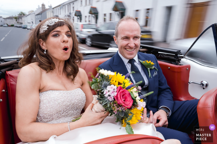 Photo by: <a href="https://www.wpja.com/contests/2019-v12/best-wedding-photographers/2548574">Rich Calver - Lisburn County Antrim</a> Orange Tree House, Greyabbey, Northern Ireland documentary wedding photographer | Mustang Driver puts foot down in wedding car with bride and groom in the backseat - Slow shutter bridal ride