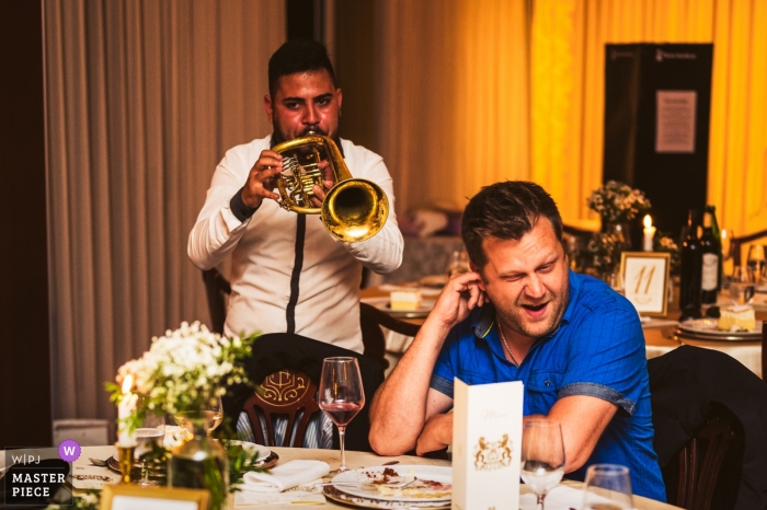 Hochzeitsempfangsfotografie – Grand Hotel Toplice, Bled, Slowenien – Ein Gast ist ein Partybrecher – Musiker mit lauter Hupe