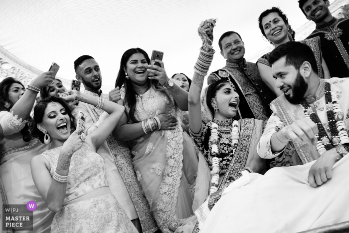 Ceremonia de Inglaterra: reportaje de bodas en la fotografía de la novia que ganó la ronda de juegos que se celebró después de la ceremonia con familiares y amigos. Momento divertido cuando la novia ganó la ronda y familiares / amigos disfrutando y tomando fotos.