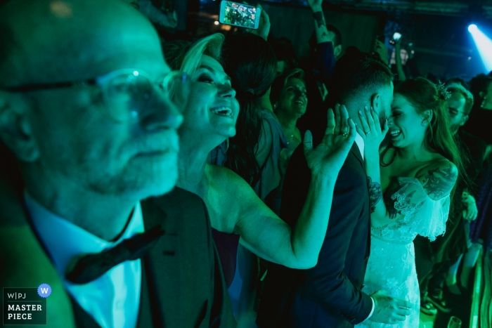 bride and groom dancing under green and blue lights Vinícola Laurentia - Barra do Ribeiro - Brasil wedding photography of bride and groom dancing under green and blue lights