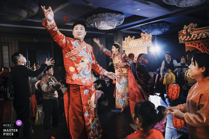 the couple scatters red envelopes China hotel photographer - At the end of the wedding ceremony, the couple scattered red envelopes to share happy.