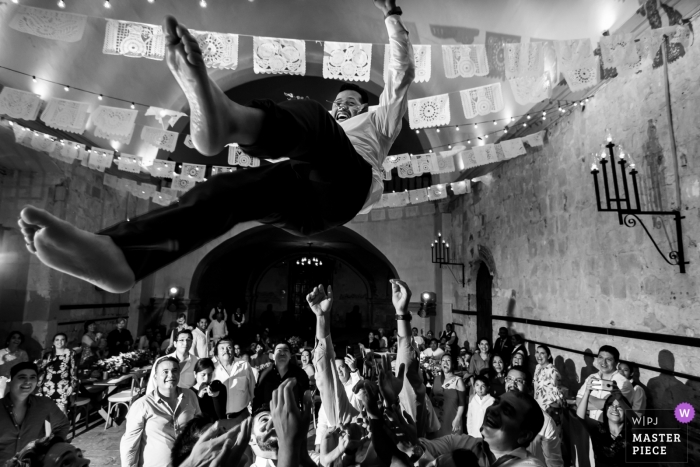Foto von: <a href="https://www.wpja.com/contests/2019-v12/best-wedding-photographers/2548794"> Douglas Favero - Oaxaca de Juárez Oaxaca </a> Hotel Quinta Real, Centro Histórico, Oaxaca, Mexiko Hochzeitsfotograf - Bild des Bräutigams bei der Hochzeitsfeier in die Luft schleudern.