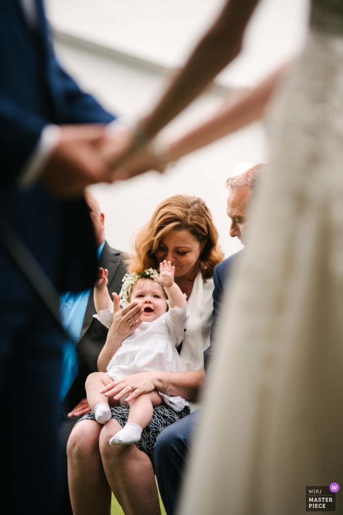 Photo by: <a href="https://www.wpja.com/contests/2019-v13/best-wedding-photographers/2549142">Viara Mileva - Bath Ontario</a> Outside ceremony venue photography - Baby is happy to see her parents during ceremony