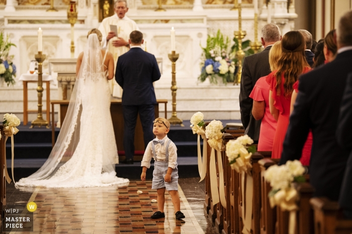 Kościół Najświętszej Marii Panny, Charlestown, Massachusetts — Fotografia ślubna — Osoba niosąca pierścionek w przejściu podczas ceremonii