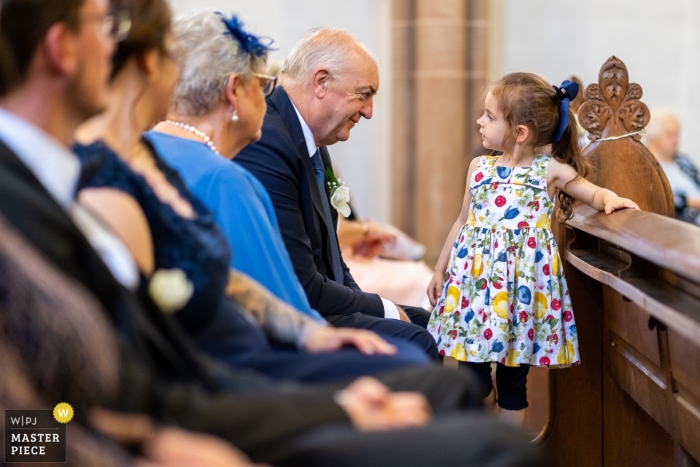 Photo: <a href="https://www.wpja.com/contests/2019-v13/best-wedding-photographers/2549855"> David Anton - Oberkirch </a> Photographe de mariage à l'église de Luxembourg - Grand-père regarde directement dans les yeux de sa petite-fille lors de la cérémonie