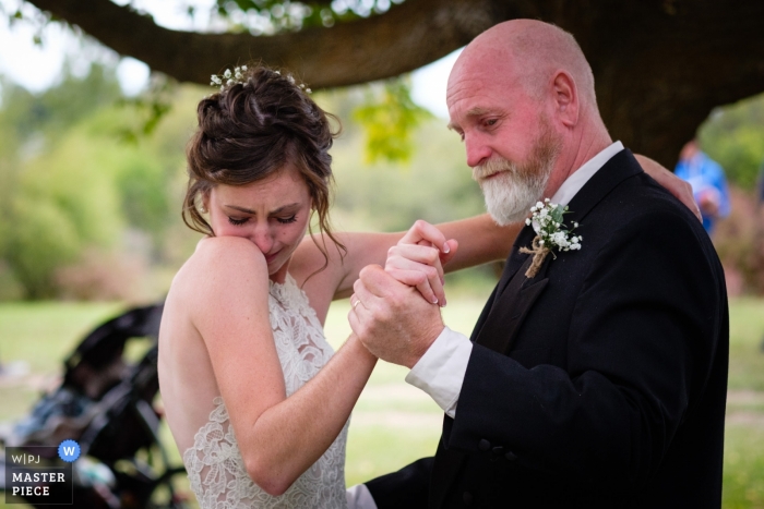 Photo by: <a href="https://www.wpja.com/contests/2019-v13/best-wedding-photographers/2550198">Kent Meireis - Kalispell Montana</a> Wedding Photography from the Bride's family farm near Kalispell Montana - A bride tears up at the start of her father/daughter wedding dance.