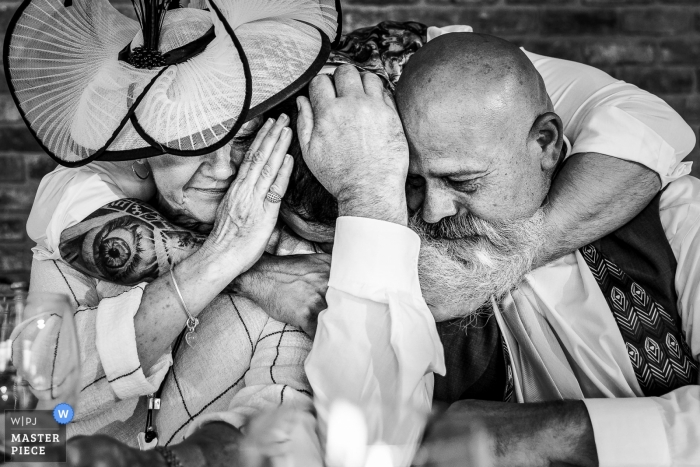 Photo by: <a href="https://www.wpja.com/contests/2019-v13/best-wedding-photographers/2550287">Andy Griffiths - St. Helens Lancashire</a> Pryors Hayes Wedding Photography in Black and White - Groom hugging his mum and dad