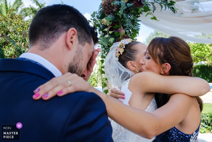Foto: <a href="https://www.wpja.com/contests/2019-v13/best-wedding-photographers/2550763"> Toni Miranda - Alcoy Alicante </a> Cocentaina-Hochzeitsfoto der Braut eine Umarmung empfangend, während Bräutigam bereitsteht.