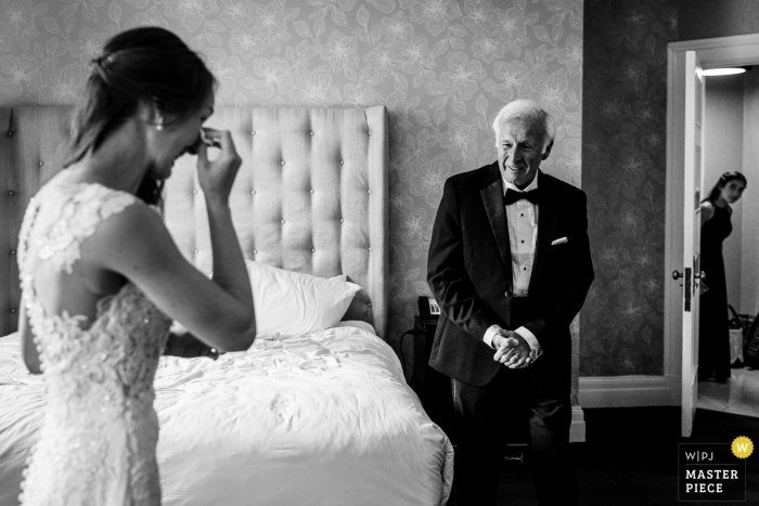 Photo: <a href="https://www.wpja.com/contests/2019-v13/best-wedding-photographers/2550822"> JD Land - Marlton, New Jersey </a> Photographie d'hôtel pendant la préparation | La mariée a vu son père pour la première fois le jour du mariage avec sa demoiselle d’honneur junior furtive.