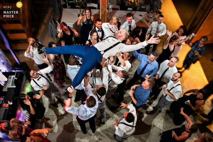 New Jersey Wedding Photographer | Groom is lifted into the air during reception and he decides to drink his beer 