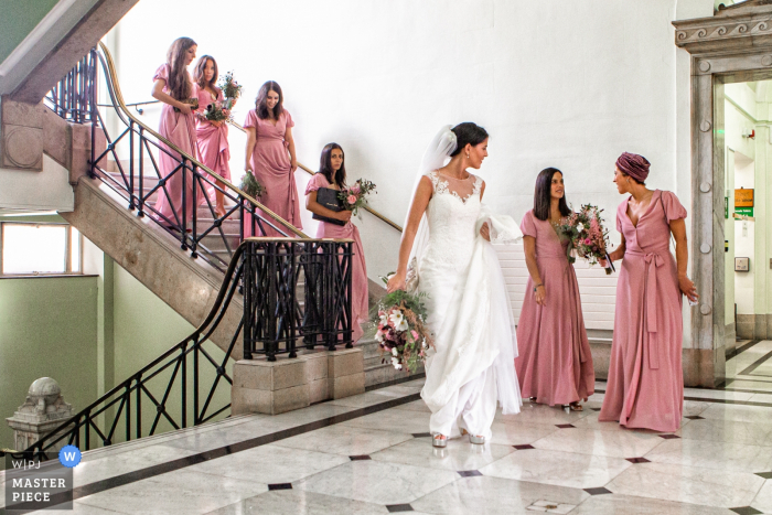 Photo by: <a href="https://www.wpja.com/contests/2019-v13/best-wedding-photographers/2551169">Obi Nwokedi - London London</a> Islington Town Hall, London Wedding Photography of the Bride and Bridesmaids coming down the Stairs in their Dresses with Flowers