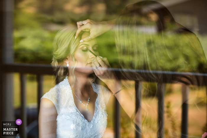 Photo by: <a href="https://www.wpja.com/contests/2019-v13/best-wedding-photographers/2551228">Joyce Perlman - San Francisco California</a> Wedding Photography from Lula Cellars, Anderson Valley, CA | Reflection of vineyards in a window with the bride getting her makeup done