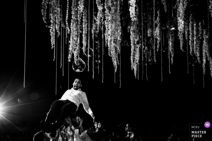 Photo by: <a href="https://www.wpja.com/contests/2019-v13/best-wedding-photographers/2551252">Miguel Onieva - Madrid Madrid</a> Spain Wedding Venue Photography | Groom flying on the dance floor above the guests in this black and white photo