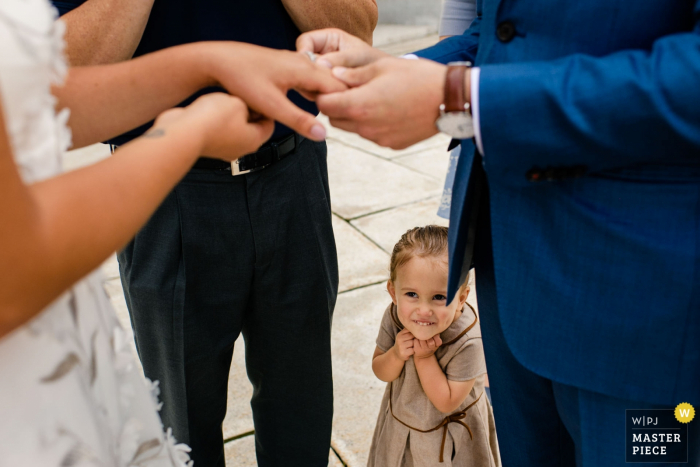 Foto von: <a href="https://www.wpja.com/contests/2019-v13/best-wedding-photographers/2551438"> Ilana Bar-av - Madison Wisconsin </a> Wisconsin State Capitol Hochzeitsfotograf | Die Nichte des Bräutigams lächelt, als Braut und Bräutigam die Ringe tauschen