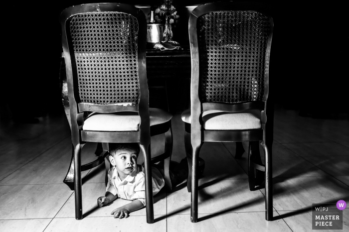 black and white with chairs and hiding boy Paulinia Wedding Photography - Image contains: black and white, chairs, boy, tile floor, table