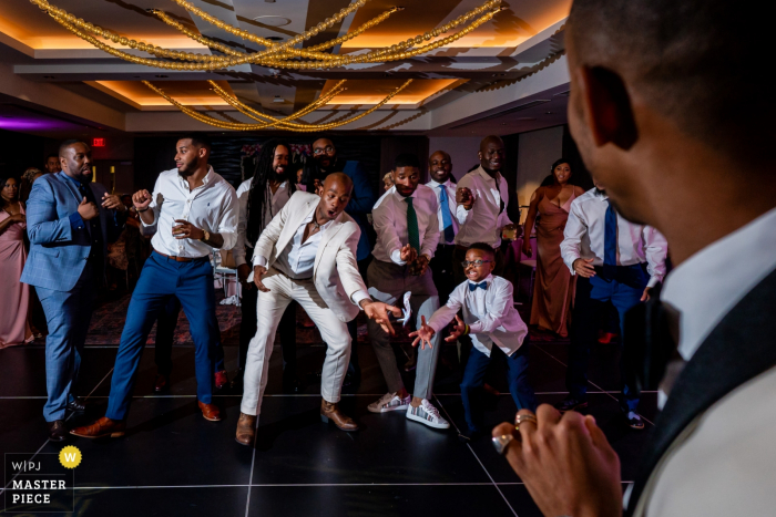 University of Maryland Hotel, College Park, MD Fotografia di matrimonio di un bambino e un groomsman che si tuffano per la giarrettiera