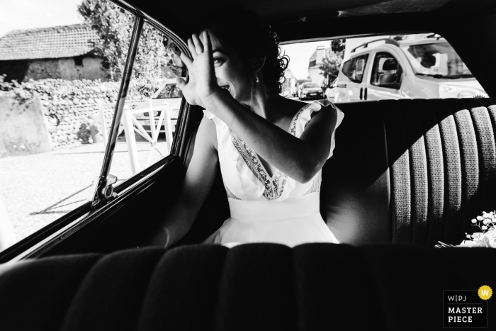 Photo by: <a href="https://www.wpja.com/contests/2019-v14/best-wedding-photographers/2552229">Sylvain Garderes - Beost </a> Pau, France wedding photography of the bride in the car waving, on her way to the ceremony