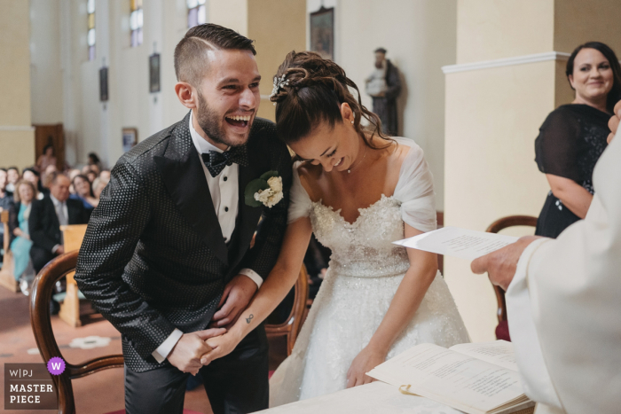 Photo by: <a href="https://www.wpja.com/contests/2019-v14/best-wedding-photographers/2552248">Sabrina Vinci - Civitanova Marche Macerata</a> Chiesa Sant'Anna wedding photograph of the bride and groom laughing as their realize the ring was being put on the wrong hand.