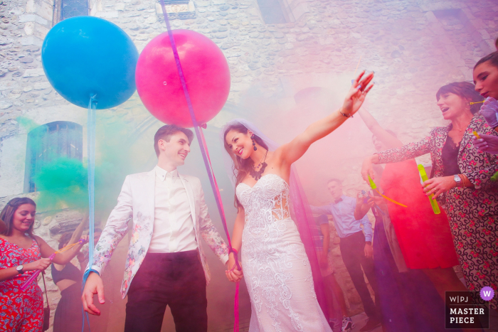 Frankreich-Hochzeitsphotographie der Braut und des Bräutigams, die eine Kirche mit bunten Ballonen herausnehmen.