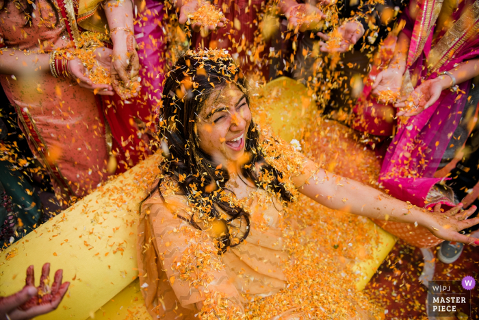 Fotografia di matrimonio dalla casa della sposa a Delhi | Questo è stato un momento dopo la cerimonia Haldi, dove tutti applicano la pasta di curcuma alla sposa e poi la inondano di fiori in segno di affetto