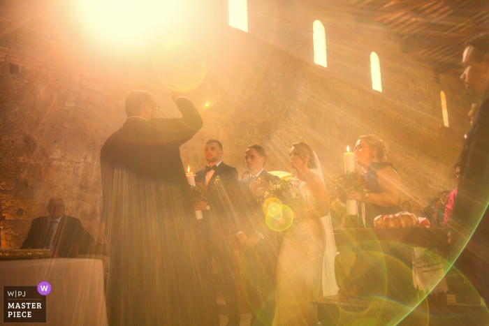 Fotografo di matrimoni per Abbazia San Giusto - La luce del sole illumina la coppia durante la benedizione