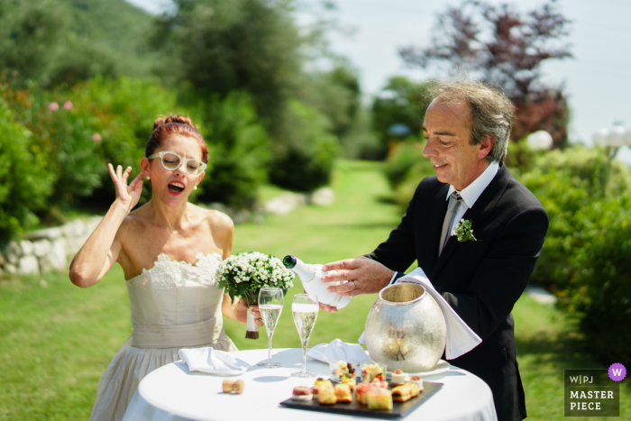 Foto von: Alessandro Di Noia - Gussago Brescia Antica Corte San Zago, Salò (Bs) - Hochzeitsfotograf - Die Braut legt ihre Hand ans Ohr, um den Chor der Gäste zu hören