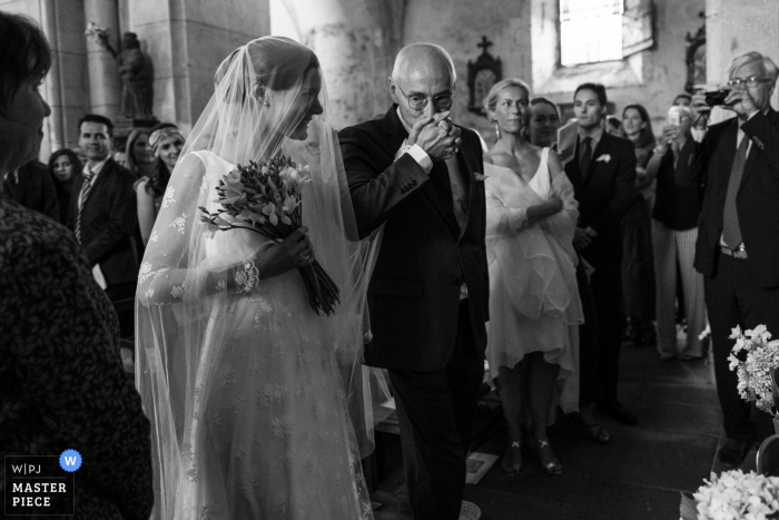 Fotógrafo de cerimônia de casamento em Ambazac. Pai beija sua filha na igreja