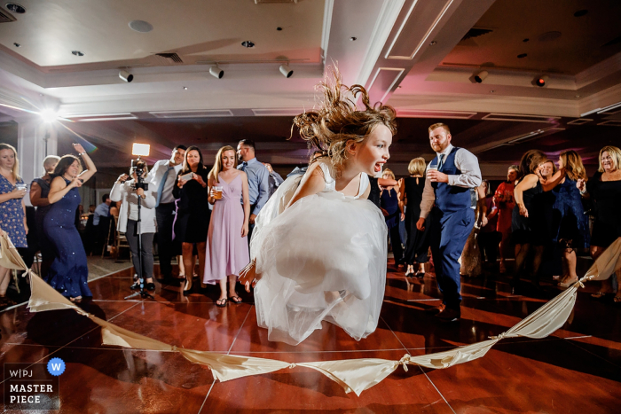 Photo by: <a href="https://www.wpja.com/contests/2019-v14/best-wedding-photographers/2553225">Alex Paul - Boston Massachusetts</a> Wedding Photography from Venue Willowbend Country Club, Mashpee, MA - kids on the dancefloor jumping napkin rope