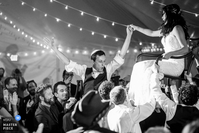 hora dance with bride and groom in chairs Five Bridge Inn, Rehoboth, MA Wedding Reception Venue photography of hora dance with bride and groom in chairs