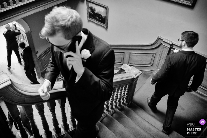 Photo by: <a href="https://www.wpja.com/contests/2019-v14/best-wedding-photographers/2553390">Ian Bursill - Loughborough Leicestershire</a> Wedding Reportage Photography from Sutton Bonington Hall, Loughborough, UK | A decisive moment on the stairs. At the bottom is the groom greeting a guest.