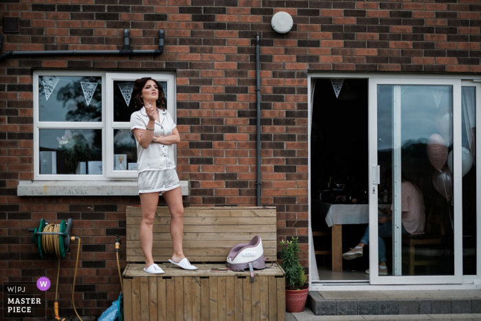 Photo by: <a href="https://www.wpja.com/contests/2019-v14/best-wedding-photographers/2553468">Jonathan Ryder - Belfast County Antrim</a> At the bride's home in Lisburn, Northern Ireland - Wedding Reportage Photos - The bride takes a moment out from the morning prep to have a cigarette